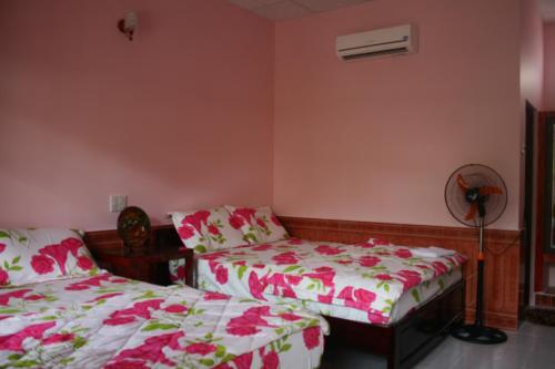 a bedroom with two beds and a fan at Minh Anh Garden Hotel in Mui Ne
