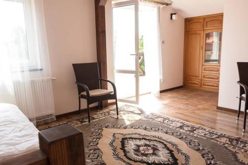 1 dormitorio con 1 cama, 2 sillas y puerta en Apartament na Mazurach, en Ostróda