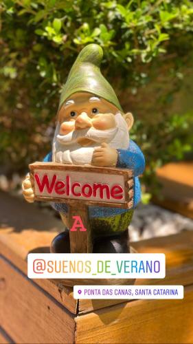 a statue of a gnome holding a welcome sign at Posada Sueños De Verano in Florianópolis