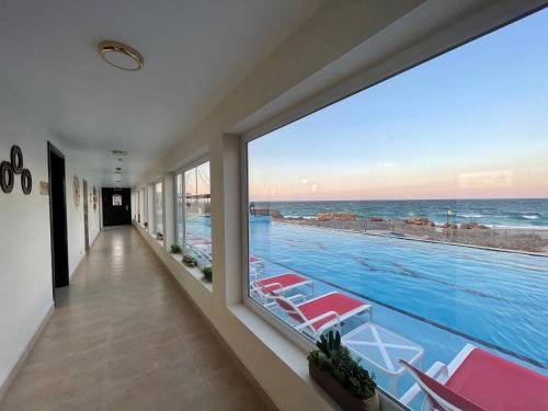 a swimming pool with a view of the ocean at Turtle Beach Resort in Al Ḩadd