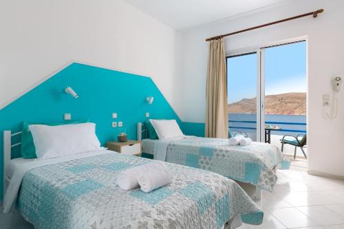 two beds in a room with a view of the ocean at marina beach in Livadia