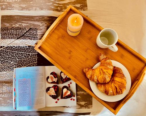 a tray with a book and a cup of coffee and pastries at Bobo’s Home in Iglesias