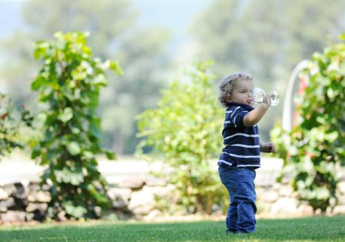 a young child drinking from a water bottle at Winzerhof - Gästehaus Stöger in Dürnstein