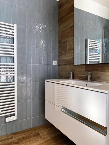 une salle de bain avec un lavabo blanc et un miroir dans l'établissement VILLA ISULA by Intendance Excellency, à Sainte-Lucie de Porto-Vecchio