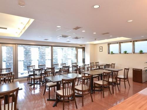 uma sala de jantar com mesas, cadeiras e janelas em Sapporo Clark Hotel em Sapporo