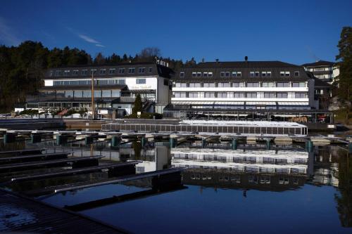 a group of buildings next to a body of water at Holmen Fjordhotell in Nesbru