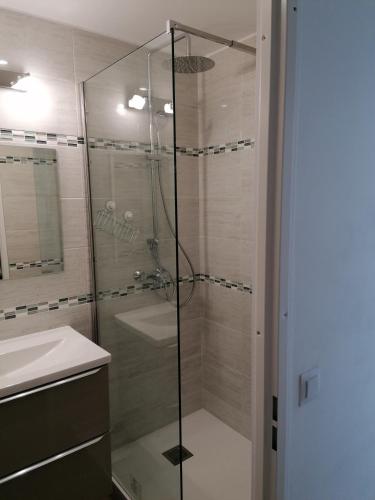 une douche avec une porte vitrée dans une salle de bain dans l'établissement Les Marines, à Courseulles-sur-Mer
