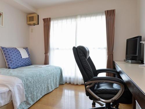 um quarto com uma secretária, uma cadeira e uma cama em Sapporo Clark Hotel em Sapporo