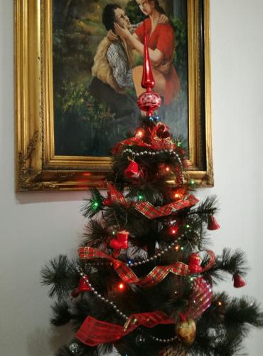 a christmas tree in front of a painting at Pensiunea La Poarta Bucovinei in Suceava