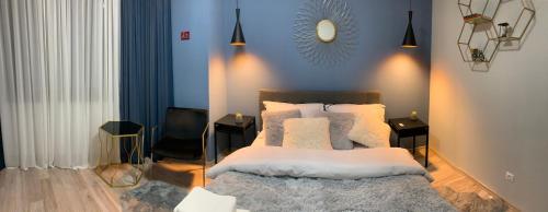 a bedroom with a bed and a blue wall at Matteo apartment in Iaşi