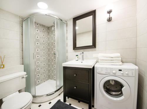 a bathroom with a washing machine and a shower at Tiltų 5 Studio in Klaipėda