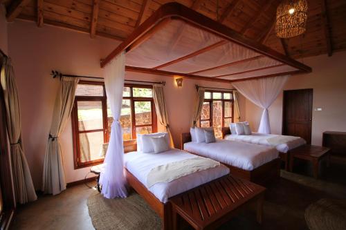 a bedroom with two beds in a room with windows at Ngorongoro Marera Mountain View Lodge in Karatu