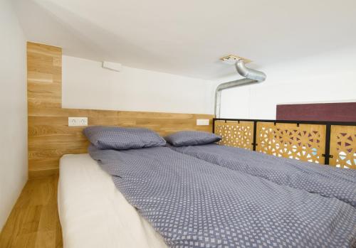 een bed met twee blauwe kussens in een slaapkamer bij Tiltų 5 Studio in Klaipėda
