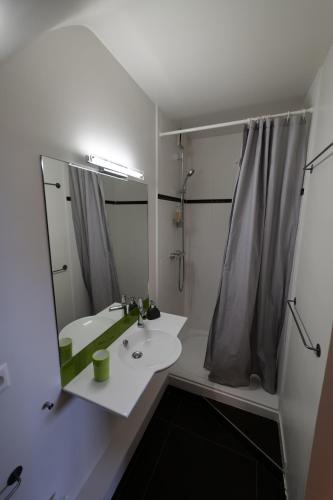a white bathroom with a sink and a shower at Libellules in Villeneuve