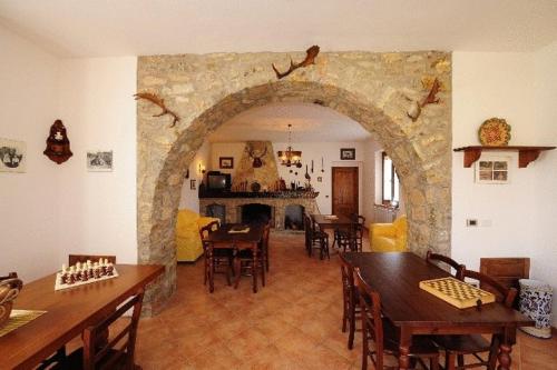a living room with an archway with tables and chairs at Agriturismo Villa Martis in Passignano sul Trasimeno