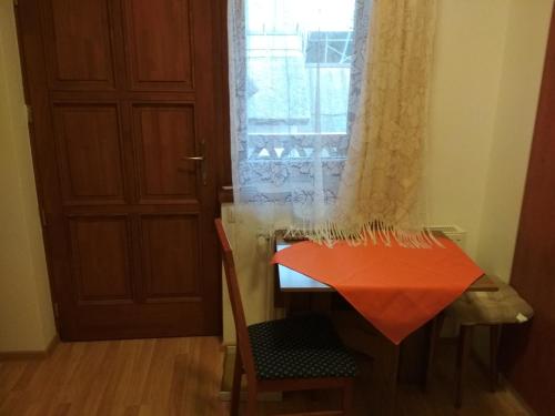 a room with a table and a chair and a door at Júlia Vendégház in Tar
