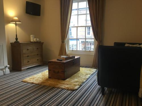 a room with a bed and a dresser at Unicorn Hotel in Llanidloes