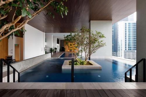 an indoor pool with a tree in a building at EST Bangsar KL Sentral by Greater Stay in Kuala Lumpur
