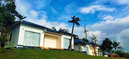 a church with a palm tree and a windmill at Peakaavu Cottages in Idukki