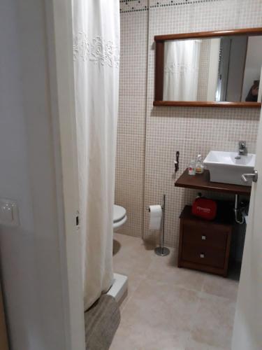 baño con cortina de ducha blanca y lavamanos en Apartamento en la costa brava en Palafrugell