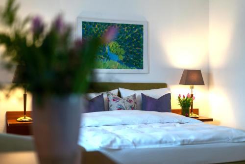 a bedroom with a bed and a vase with flowers at Hotel Engbert in Oelde