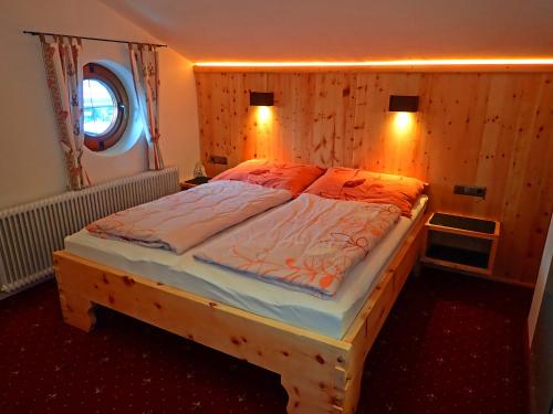 1 dormitorio con 1 cama grande con 2 luces. en Haus Alpenfriede, en Ramsau im Zillertal