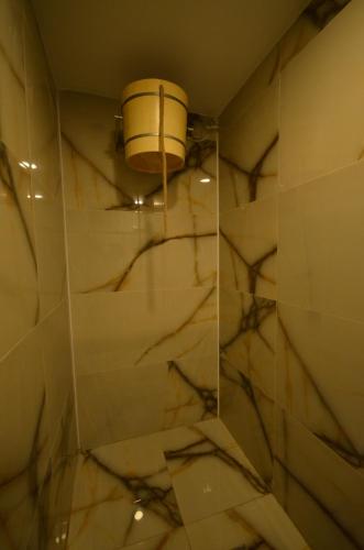 a bathroom with a shower with a bucket on the wall at Snowflake Dag Hotel & SPA in Sarıkamıs