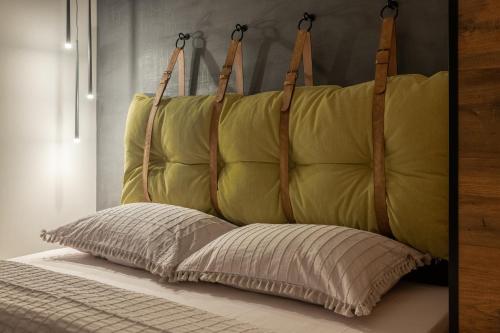 Una cama con una almohada amarilla encima. en Spirit studio en Varna