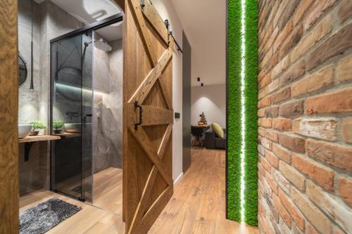 una puerta giratoria en un baño con una pared de ladrillo en Spirit studio en Varna