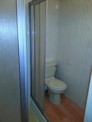 a bathroom with a toilet and a glass shower at Jesmond International Hotel in Blackpool