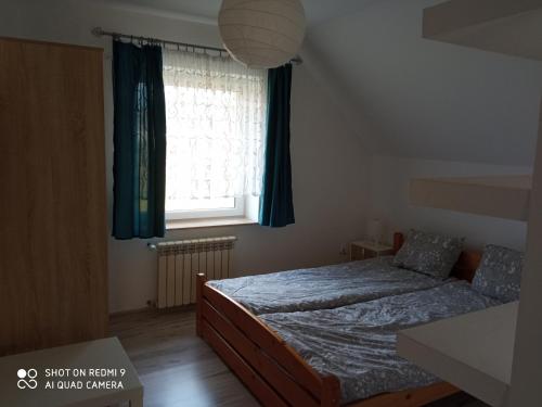 um quarto com uma cama e uma janela em Willa na Wczasowej em Wegierska Górka