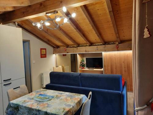 a living room with a table and a blue couch at Chalet la sapiniere in La Chapelle-dʼAbondance