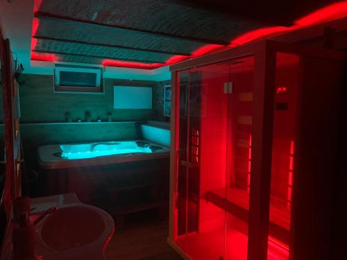 a bathroom with a tub and a red light at Balaton Wellness Tom Cat nyaraló in Kővágóörs