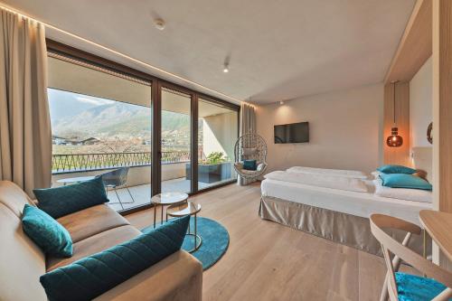 Una habitación de hotel con una cama y una ventana grande. en Hotel Wiesenhof, en Lagundo