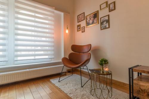a brown chair in a room with a window at Guesthouse Westende in Middelkerke