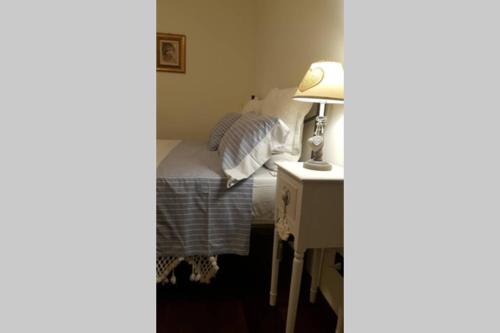 a bedroom with a bed and a lamp on a desk at Casa Emel in Potenza Picena