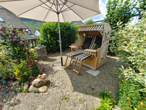 a garden with a chair and an umbrella at Ferienhaus Stülb in Zeltingen-Rachtig