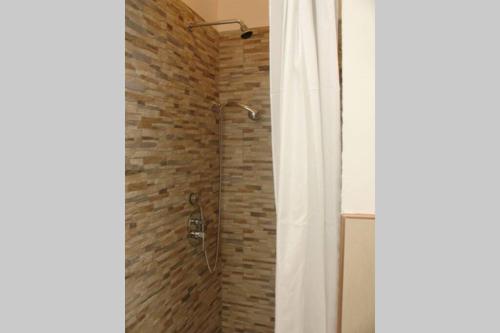 een badkamer met een douche en een bakstenen muur bij Villetta sul Mare a Gallipoli Padula Bianca in Alezio
