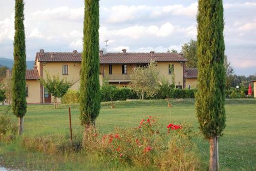 a house in the middle of a field with trees at il Chiassetto Agriturismo No Kids in Cascina