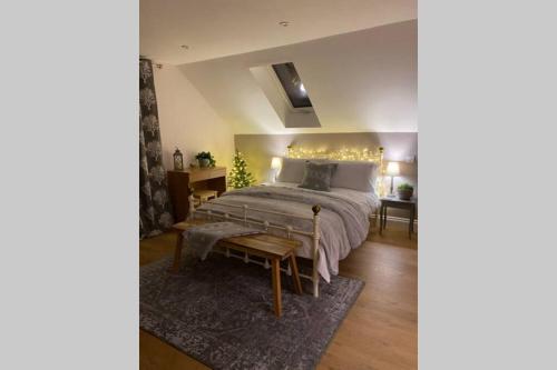 a bedroom with a large bed and a table at Prospect Perch - Studio Apartment, Wells in Wells