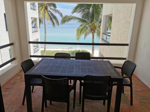 a table and chairs in a balcony with a view of the ocean at Condominios Orca in Progreso