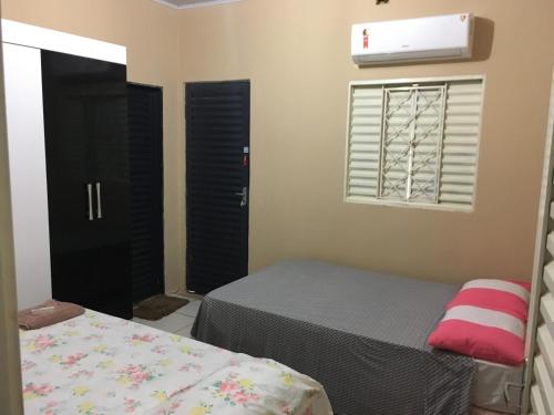 um quarto com 2 camas, uma janela e uma cama em CASA DE TEMPORADA NO JALAPÃO (CAP 11 PESSOAS) em Mateiros