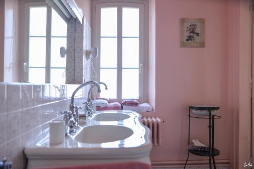 a bathroom with a white sink and a window at L'Oustal in Bourges