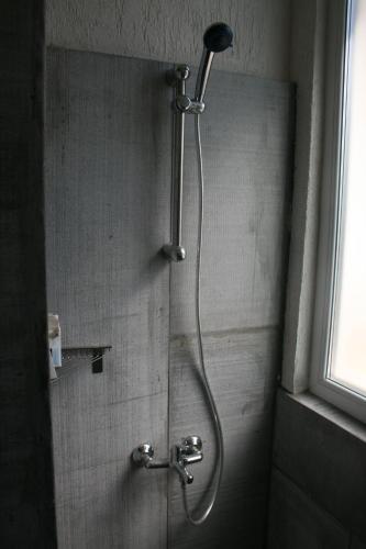 a shower with a shower head in a bathroom at Hostel Iliana Общежитие Илияна in Elin Pelin