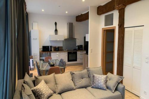 a living room with a couch and a kitchen at Appartement lumineux et cosy avec jardin vue sur chateau près Port en Bessin, Bayeux et Omaha Beach in Commes