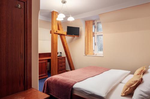 a bedroom with a bed and a desk in it at Penzion Vila Julie in Jilemnice
