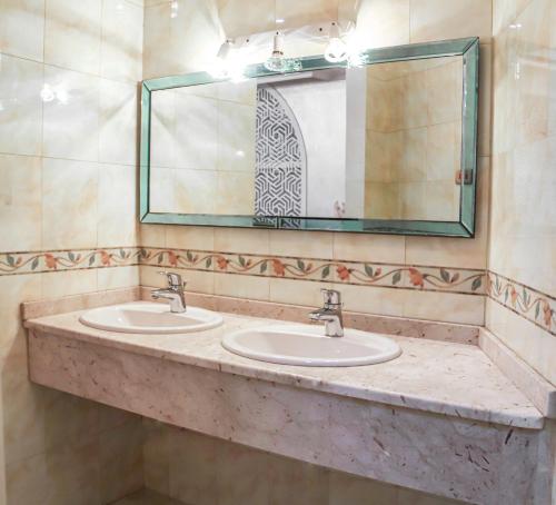 a bathroom with two sinks and a large mirror at Staycation Home Shj in Sharjah