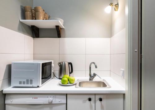 a small kitchen with a sink and a microwave at Post House Rooms in Lviv