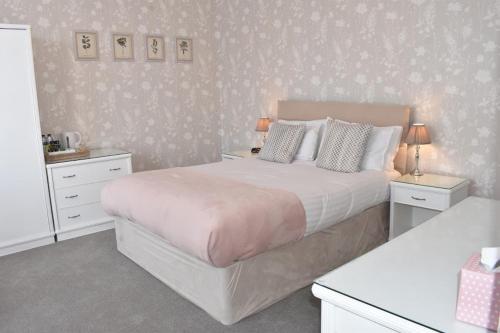 1 dormitorio con 1 cama grande y 2 mesitas de noche en The Castleton en Swanage