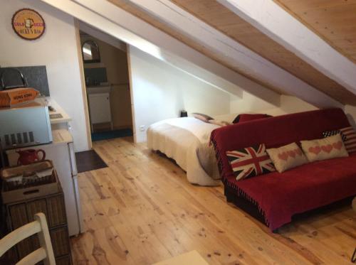 sypialnia z łóżkiem i czerwoną kanapą w obiekcie Le Carré gourmand w mieście Le Chambon-sur-Lignon